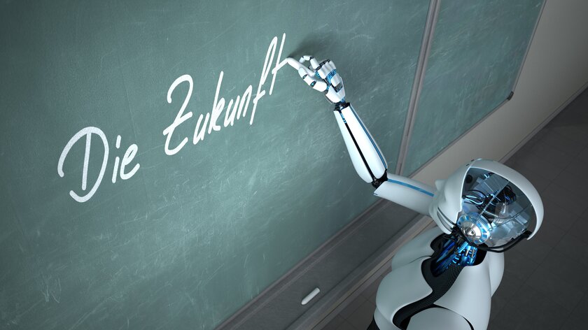 KI-Roboter schreibt mit Kreide das Wort Zukunft an eine Schiefertafel.