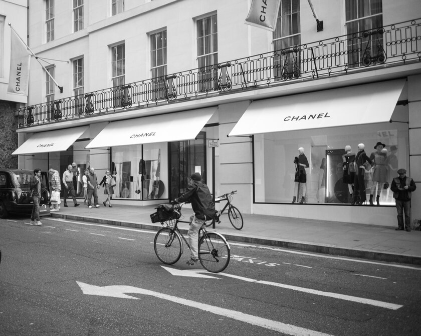 Menschen flanieren vor einem Chanel Store auf der New Bond Street in London. 