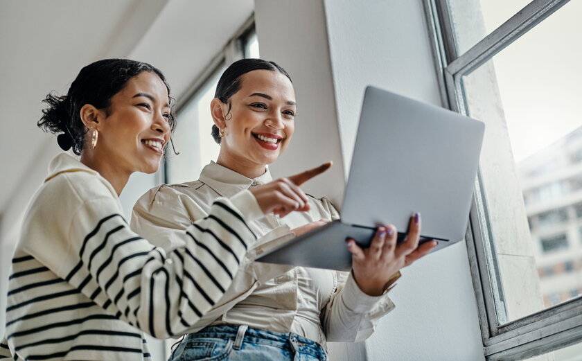 Startup-Business-Frauen-Team am Laptop freuen sich ueber Klickzahlen.