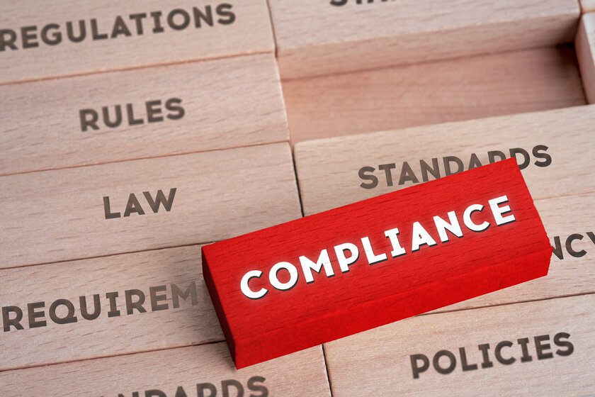 Compliance concept with various regulations written on wooden blocks 