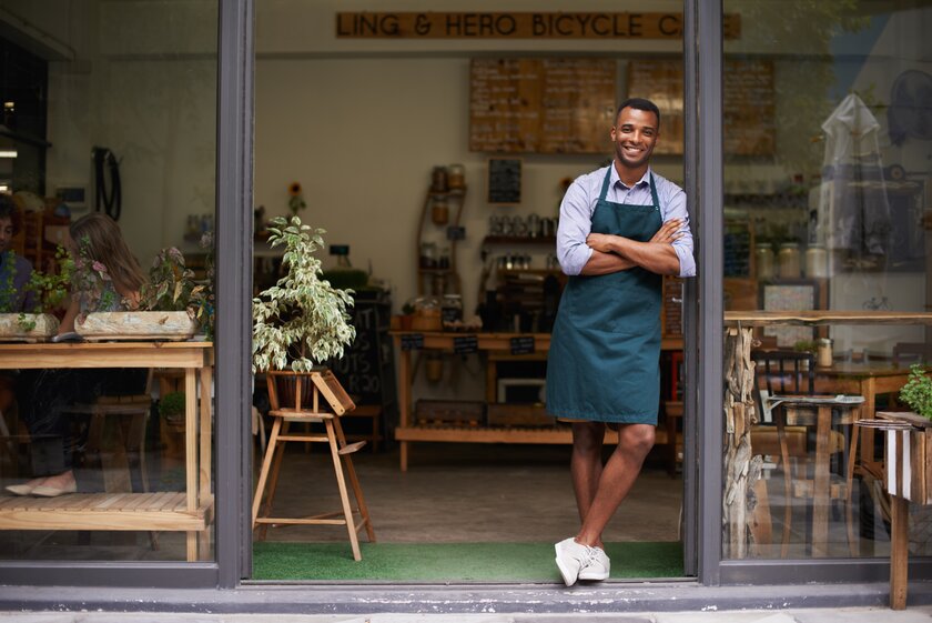 Proud owner stands in front of his bike store.