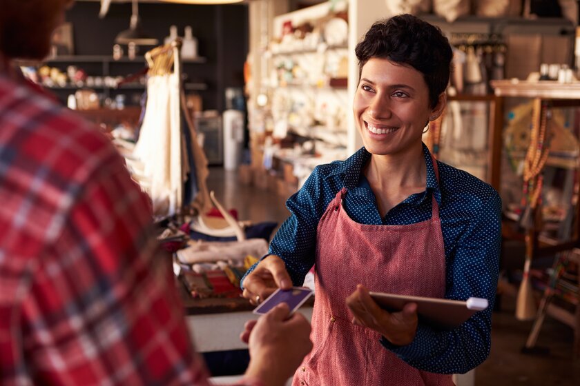 Small business owner smiling at one of her clients in her little shop.