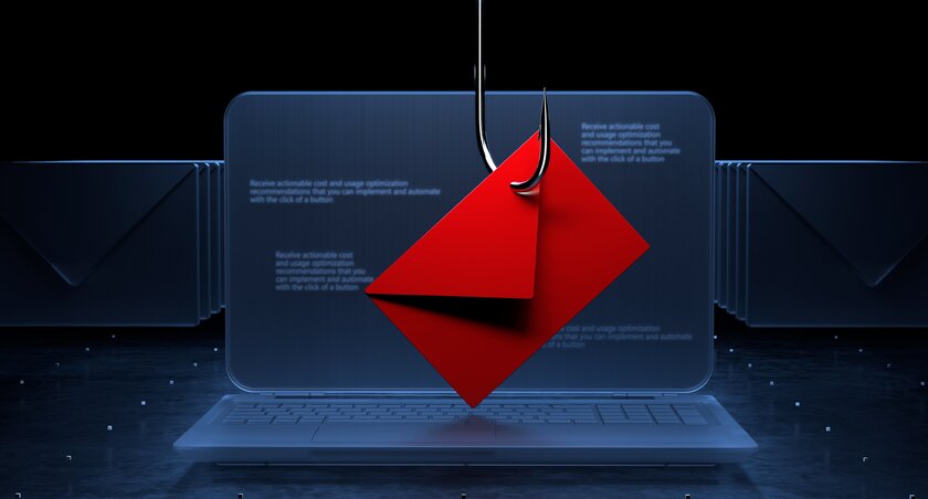 Email on hook in front of laptop as symbol for phishing attack.