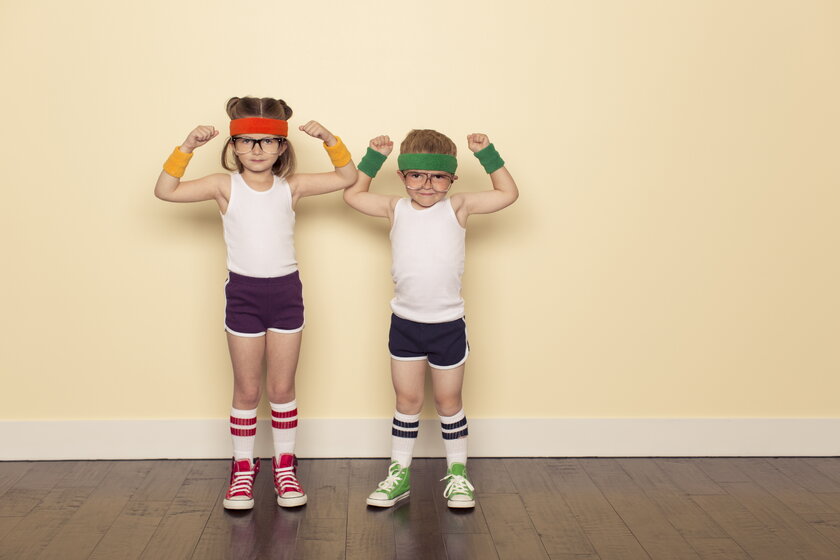 Boy and girl in sportswear with arms stretched up show muscles.