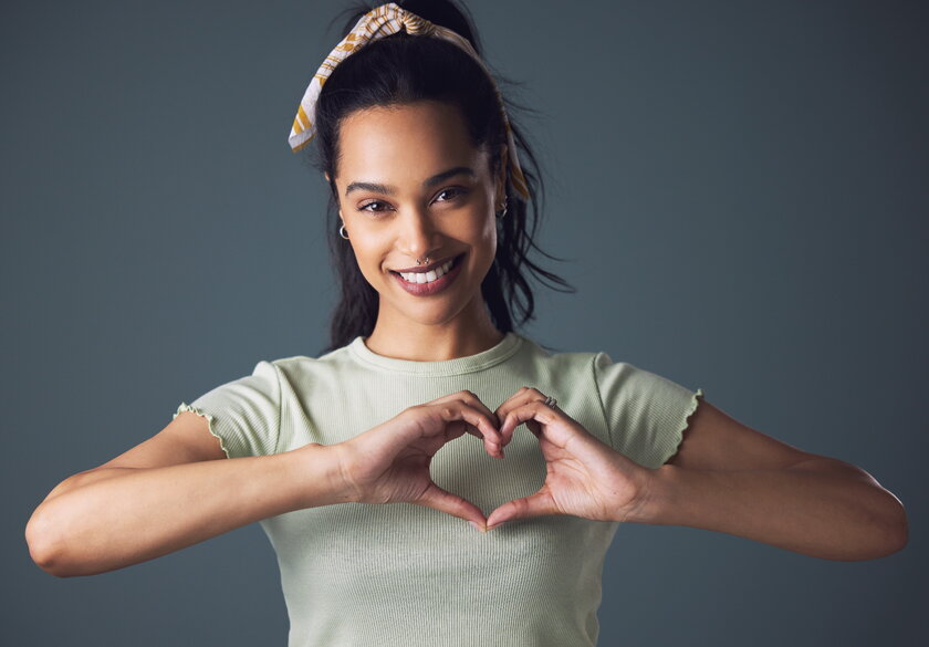 Studio shot of young woman forming heart shape.