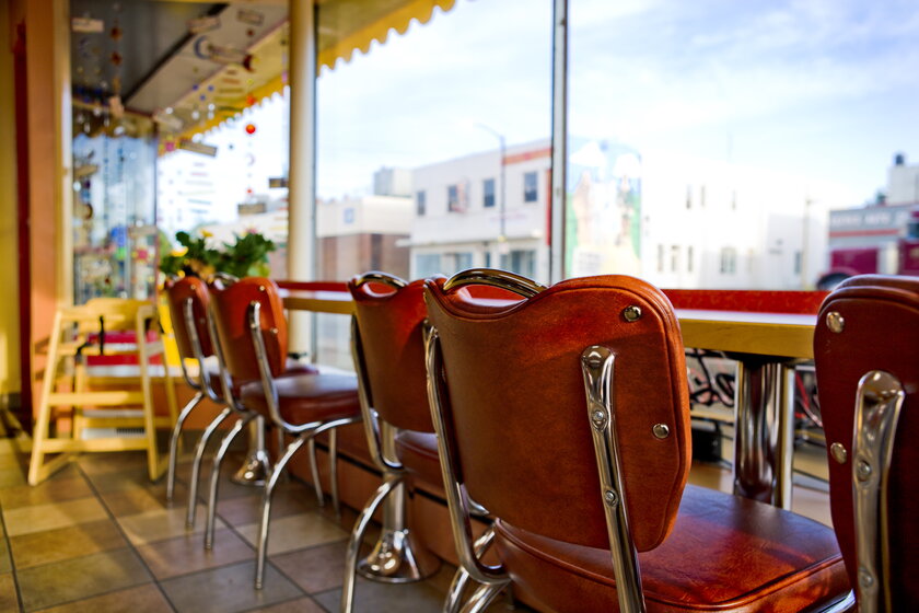 Chairs lined up in the window of a diner.