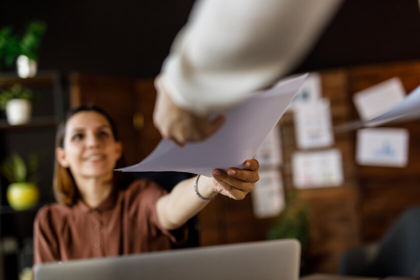 Female entrepreneur handing out her executive summary to a business partner.