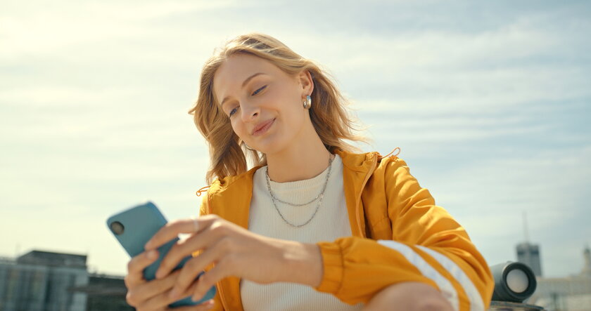 Streetwear-Student oder Gen Z-Person mit Smartphone in der Hand.