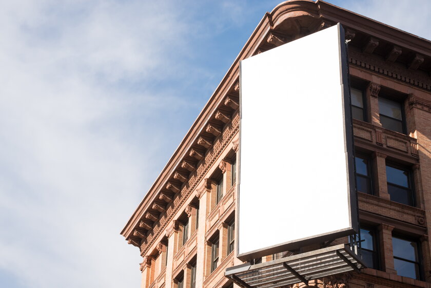 Blank billboard on brick house wall.