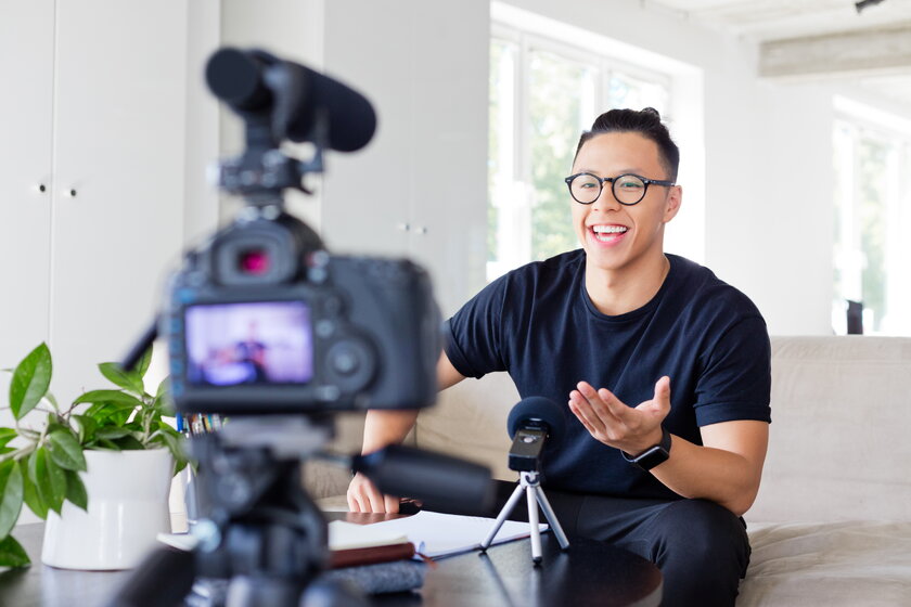 Male Asian-American Vlogger who records content on a digital camera.