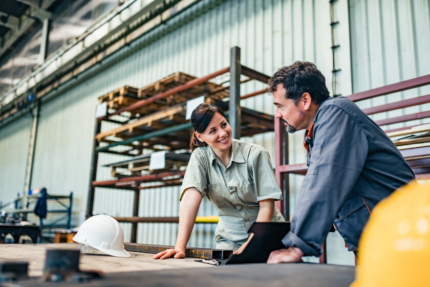 Supervisor und Ingenieur besprechen die Arbeit in der Halle einer Schwerindustrie Fabrik.