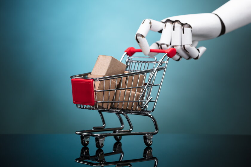Bild KI Shopping Roboterhand schiebt einen Warenkorb voll mit Kartons.